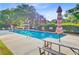 A serene community pool with a picnic table and umbrella surrounded by lush greenery at 1391 Southlake Dr, Mount Pleasant, SC 29464