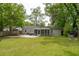 Spacious backyard with lush green grass, a patio with outdoor seating, and a screened-in porch at 14 Paula Dr, Charleston, SC 29407