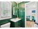 Charming bathroom with green paneling, unique mirror, and open doorway to a bright, adjacent room at 14 Paula Dr, Charleston, SC 29407