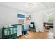 Well-lit Bedroom with stylish furnishings, including a green crib, blue chair, and modern chandelier at 14 Paula Dr, Charleston, SC 29407