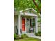Inviting front porch with a bright red door, rocking chairs, and hanging flower baskets at 14 Paula Dr, Charleston, SC 29407