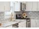 A well-lit kitchen with a stainless range, white cabinets, granite countertops, and a gold faucet at 14 Paula Dr, Charleston, SC 29407
