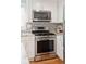 A well-appointed kitchen with stainless steel oven, patterned tile backsplash, and sleek white cabinets at 14 Paula Dr, Charleston, SC 29407