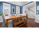 Bright dining room with blue accent wall, chandelier, hardwood floors and stairs leading to the second level at 1427 Wando View St, Charleston, SC 29492