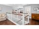 Upstairs hallway with hardwood floors, white railing, and view into living room at 1427 Wando View St, Charleston, SC 29492