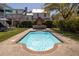 Sparkling pool with a charming brick fireplace, lush landscaping, and stylish patio furniture for outdoor relaxation at 1427 Wando View St, Charleston, SC 29492