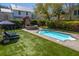 Backyard pool area featuring an outdoor fireplace, lounge seating, and a turfed lawn at 1427 Wando View St, Charleston, SC 29492