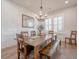 Dining room boasts a long wooden table, decorative chandelier, and a stylish mirror at 1464 Stratton Pl, Mount Pleasant, SC 29466