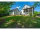 Expansive backyard with lush green grass, mature trees, and a charming white home with a screened in porch at 1510 Windlass Way, Mount Pleasant, SC 29466