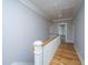 Hallway with hardwood floors and wood and white railings, offering a warm, inviting space at 1510 Windlass Way, Mount Pleasant, SC 29466