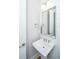 Charming powder room featuring a pedestal sink, decorative mirror, and shiplap wall paneling at 1510 Windlass Way, Mount Pleasant, SC 29466