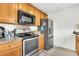Galley-style kitchen with stainless steel appliances, light wood cabinets, and ample countertop space for cooking and food preparation at 1516 Mandarin Ct, Summerville, SC 29483