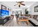 Inviting living room featuring hardwood floors, ceiling fan, a comfortable sofa, and a modern entertainment center at 1516 Mandarin Ct, Summerville, SC 29483