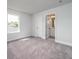 An empty bedroom featuring a door to an ensuite bathroom and natural light from a window at 154 Royal Cainhoy Way, Huger, SC 29450