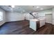 The kitchen features an island with sink and stainless steel dishwasher, white cabinetry, and hardwood floors at 154 Royal Cainhoy Way, Huger, SC 29450