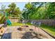 Backyard with fire pit, modern chairs, hammock, playset, and lush greenery at 1606 Stovall Ct, Johns Island, SC 29455