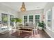 Sunlit dining room with large windows, stylish chandelier, and a cozy atmosphere for Gathering meals at 1606 Stovall Ct, Johns Island, SC 29455