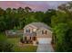 Beautiful home with a manicured lawn, covered front porch, and attached garage at twilight at 1606 Stovall Ct, Johns Island, SC 29455