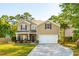 Charming two-story home with a well-manicured lawn, attached garage, and inviting front porch at 1606 Stovall Ct, Johns Island, SC 29455