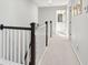 Bright hallway features neutral walls, carpet, and a white banister leading to bedrooms and bathroom at 1606 Stovall Ct, Johns Island, SC 29455