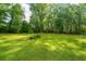 A large grassy backyard with mature trees and landscaping at 1621 Wannamaker Ave, Summerville, SC 29485