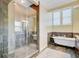 Bathroom featuring glass shower, soaking tub, and neutral tile at 1650 Long Grove Dr, Mount Pleasant, SC 29464