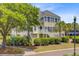 Beautiful exterior view of a two-story townhome featuring manicured landscaping, mature trees, and a private entrance at 1650 Long Grove Dr, Mount Pleasant, SC 29464