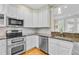 Bright kitchen featuring granite counters, stainless steel appliances, and white cabinetry at 1650 Long Grove Dr, Mount Pleasant, SC 29464