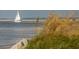Scenic view of a sailboat navigating the waterway, framed by shoreline foliage enhancing the natural beauty at 1880 Andell Bluff Blvd # F-3, Seabrook Island, SC 29455