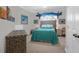 Bright bedroom featuring a queen bed with an ornate black inlaid dresser and fun coastal decor at 2009 Terrabrook Ln, Charleston, SC 29412
