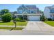 Two-story home with lush landscaping, a covered porch, a two-car garage, and a well-manicured front lawn at 2009 Terrabrook Ln, Charleston, SC 29412