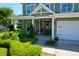 Inviting front porch with lovely landscaping, a wood door, and attached garage at 2009 Terrabrook Ln, Charleston, SC 29412