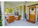 Charming front porch with ample seating, a ceiling fan, and views of the beautifully landscaped front yard at 2009 Terrabrook Ln, Charleston, SC 29412