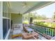 Relaxing front porch boasts a ceiling fan, cozy seating, and pleasant views of the surrounding neighborhood at 2009 Terrabrook Ln, Charleston, SC 29412