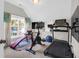 Well-lit home gym with various exercise equipment, including a treadmill, bike, and weight bench at 2009 Terrabrook Ln, Charleston, SC 29412
