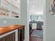 Kitchenette with wood countertop, under counter refrigerator, white cabinets, and blue rug leading into the kitchen at 2009 Terrabrook Ln, Charleston, SC 29412