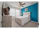 Cozy bedroom with a white bed, blue accent wall, and ceiling fan at 206 Evergreen Ave, Summerville, SC 29485