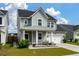 Charming two-story home with a well-manicured lawn, metal roof, and a welcoming front porch at 206 Evergreen Ave, Summerville, SC 29485