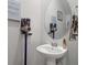 Small bathroom with a pedestal sink, mounted vacuum, and round mirror at 206 Evergreen Ave, Summerville, SC 29485