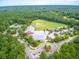 Wide aerial view of community buildings, a field, and parking nestled among green trees at 208 Cherry Grove Dr, Summerville, SC 29483