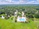 Expansive aerial view of a community pool surrounded by lush greenery and palm trees on a bright, sunny day at 208 Cherry Grove Dr, Summerville, SC 29483