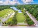 Aerial view of a grassy park area with a performance stage, surrounded by trees and a road at 208 Cherry Grove Dr, Summerville, SC 29483