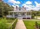 Charming white house with inviting porch, lush garden, and classic architecture at 208 Cherry Grove Dr, Summerville, SC 29483