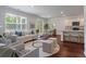 Sunlit living room with hardwood floors and open layout to kitchen and dining areas at 208 Cherry Grove Dr, Summerville, SC 29483