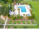 Aerial view of a modern community pool featuring sun loungers, umbrellas, and cabanas, all set within a beautiful landscape at 208 Cherry Grove Dr, Summerville, SC 29483