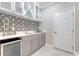 Chic bar area featuring stylish tile backsplash, under-counter beverage fridge, and sleek white countertops at 2096 Promenade Ct, Mount Pleasant, SC 29466