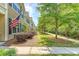 Row of townhomes with manicured lawns and patriotic decor under a partly cloudy sky at 2096 Promenade Ct, Mount Pleasant, SC 29466