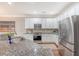 Modern kitchen with stainless steel appliances, white cabinets, and granite countertops at 2096 Promenade Ct, Mount Pleasant, SC 29466