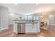 Kitchen island with sink overlooks dining area, enhanced by natural light and hardwood floors at 2096 Promenade Ct, Mount Pleasant, SC 29466