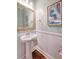 Stylish powder room with a pedestal sink, decorative mirror, and modern artwork at 2096 Promenade Ct, Mount Pleasant, SC 29466